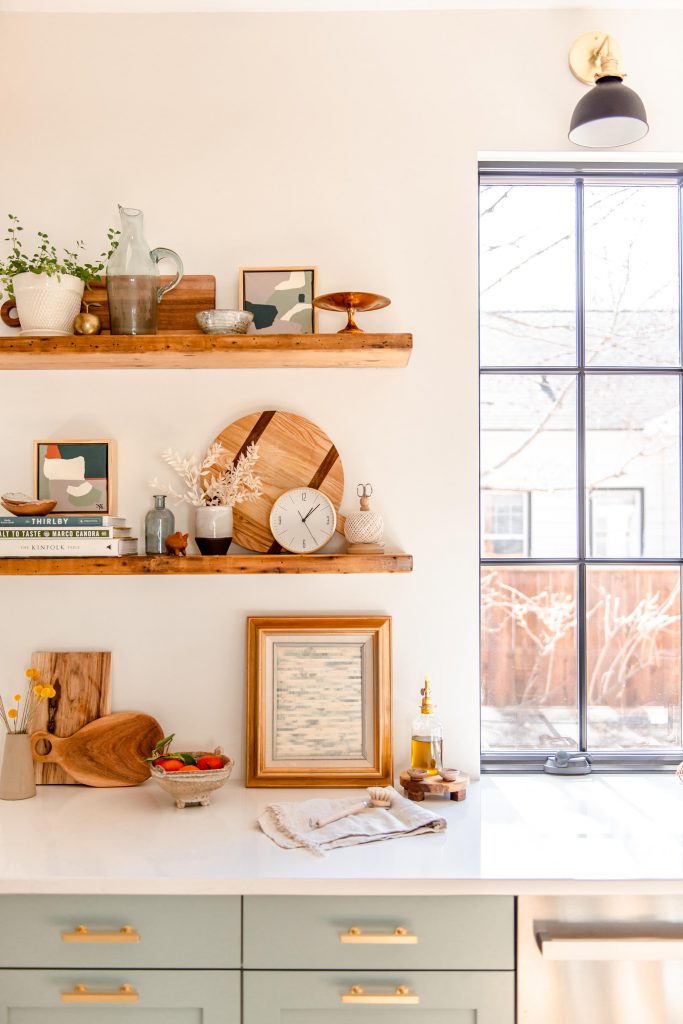 open shelving displaying dishes, plants, and a picture frame.