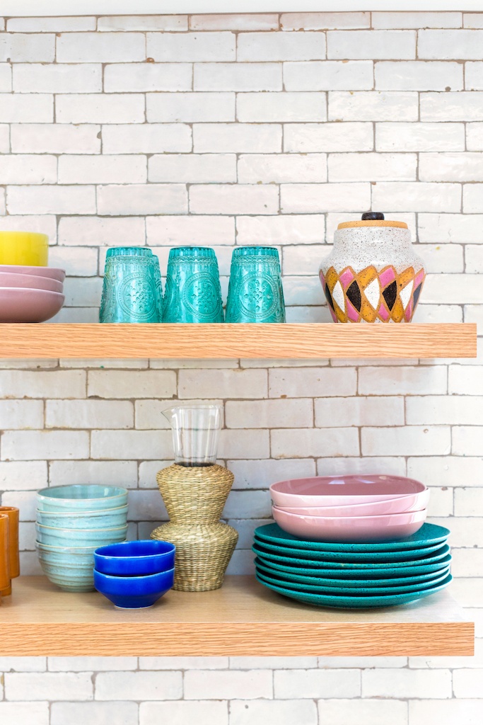 multi-colored kitchenware on open shelves.