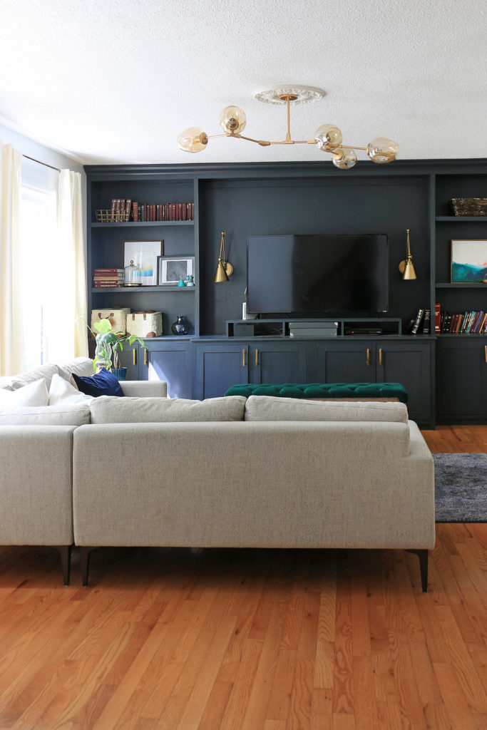 living room with black wall and neutral sectional