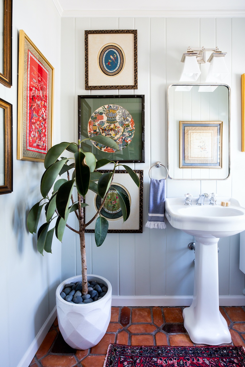 bathroom with a gallery wall and plant