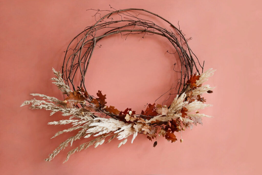 Dried floral wreath on pink background