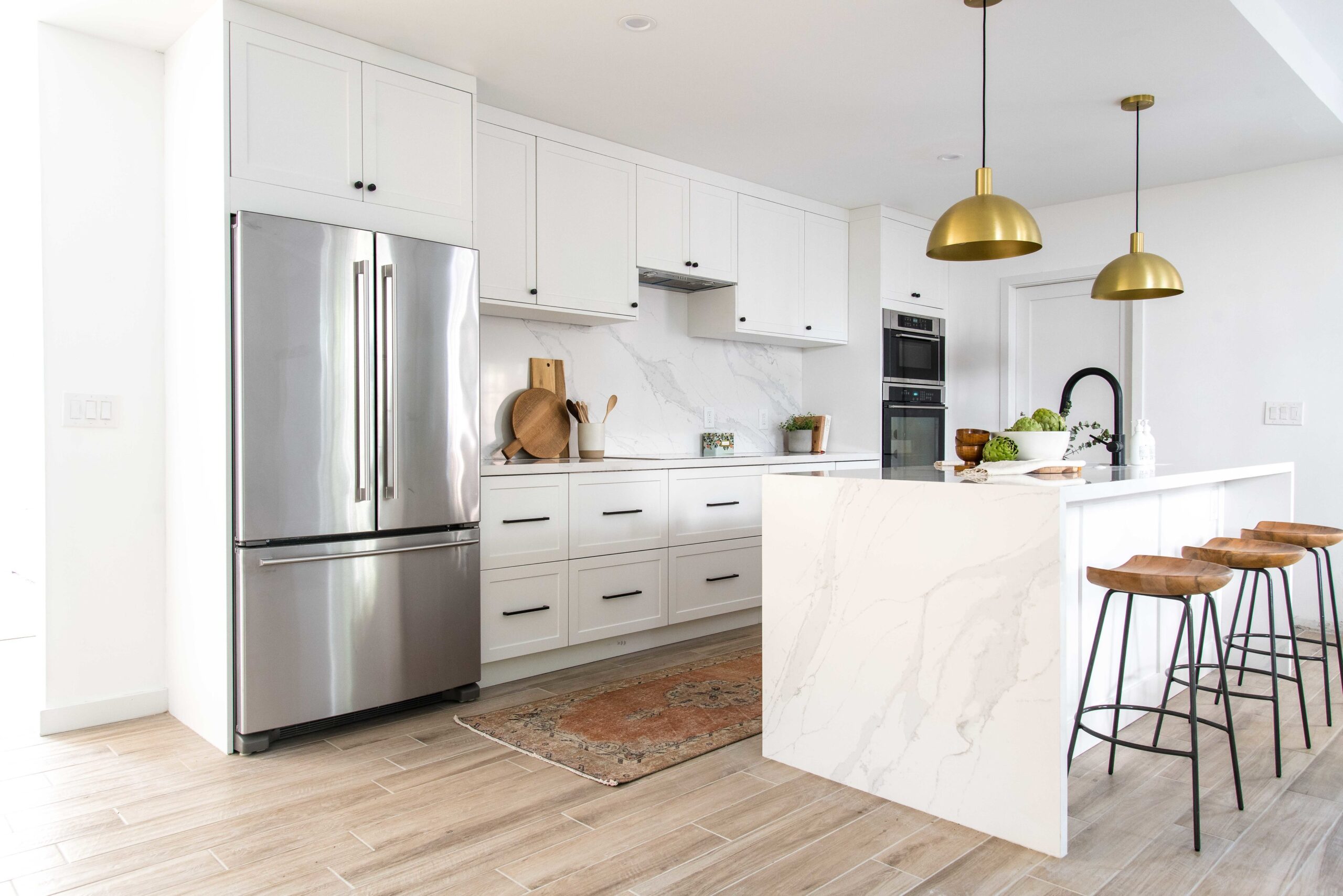 White kitchen cabinets with gold pendants