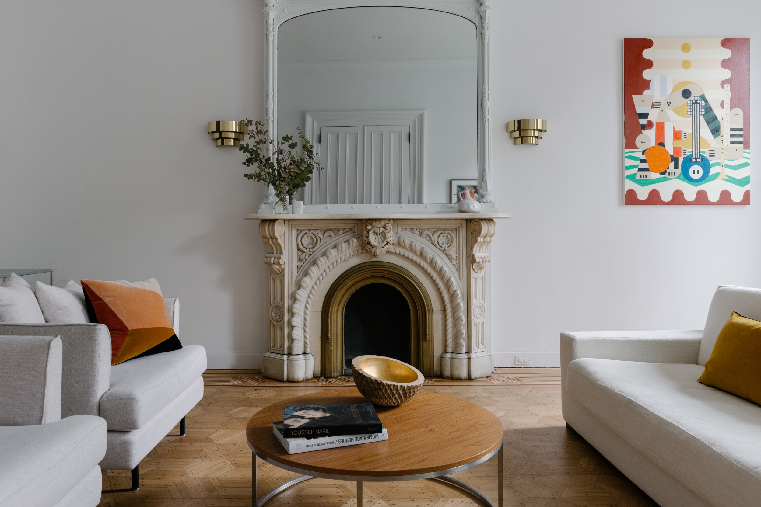 Historic fireplace with modern art in a renovated living room