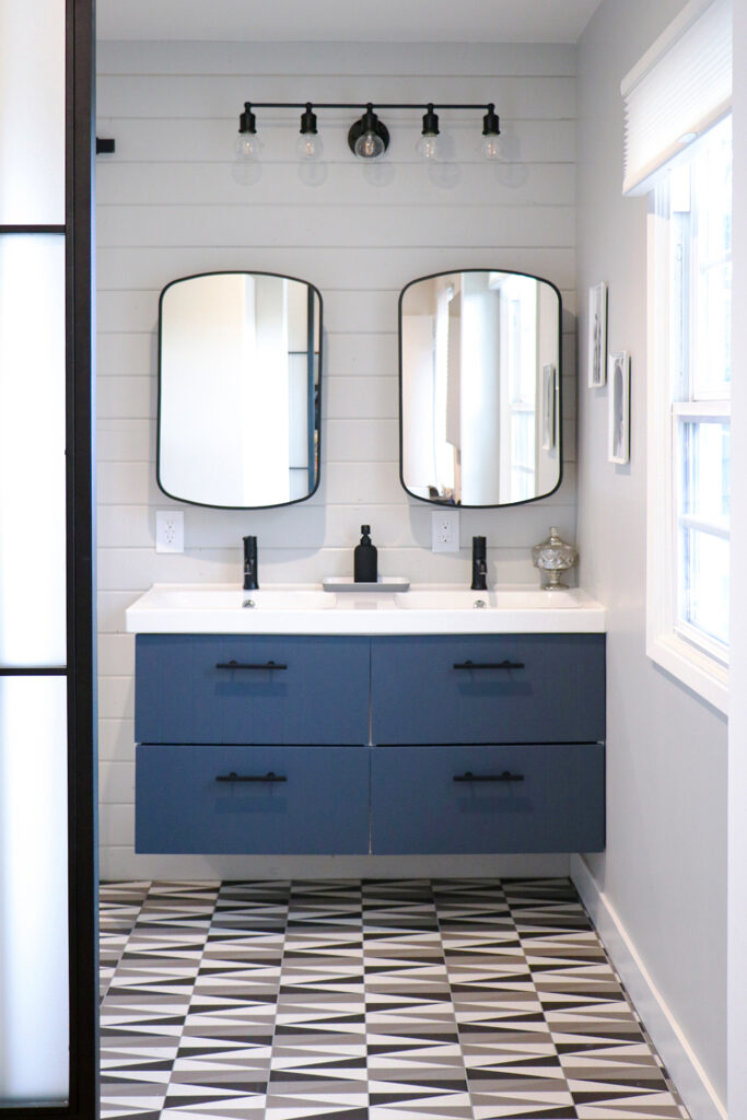 Blue bathroom vanity in a black and white space
