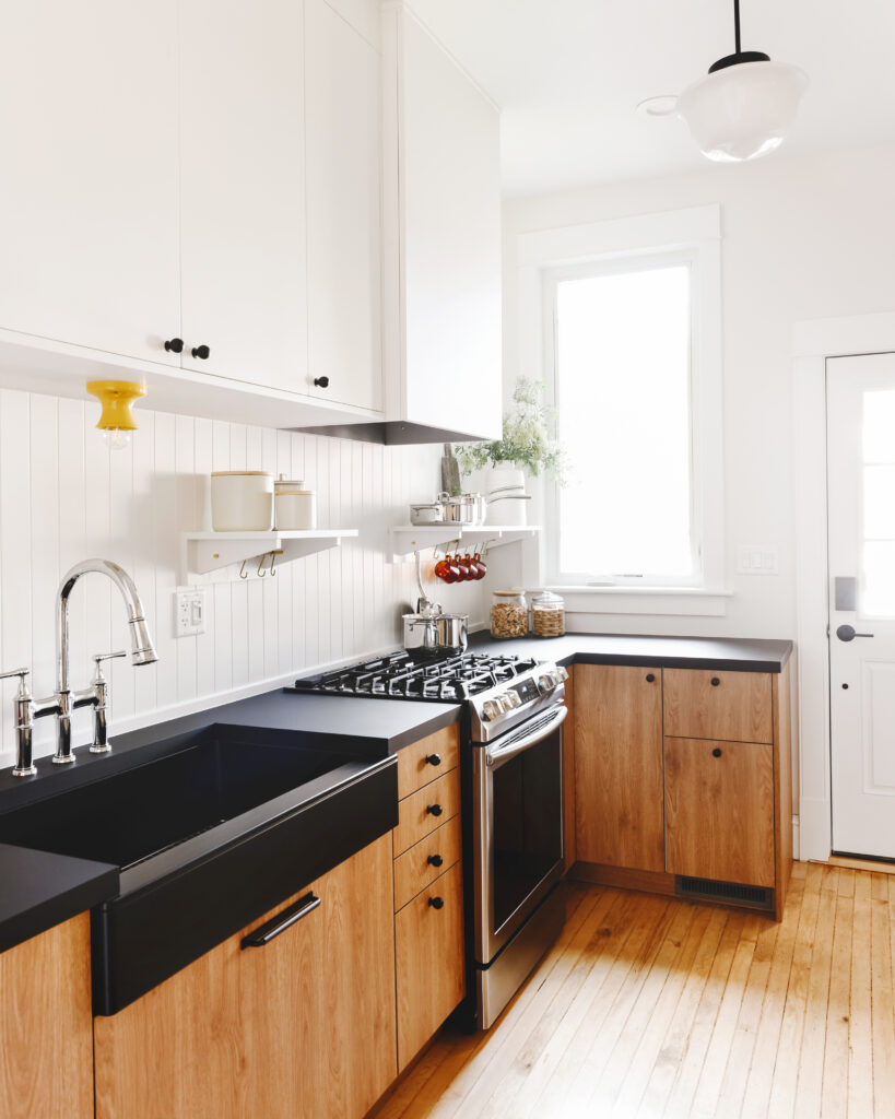 Two tone white and wood kitchen with black counters
