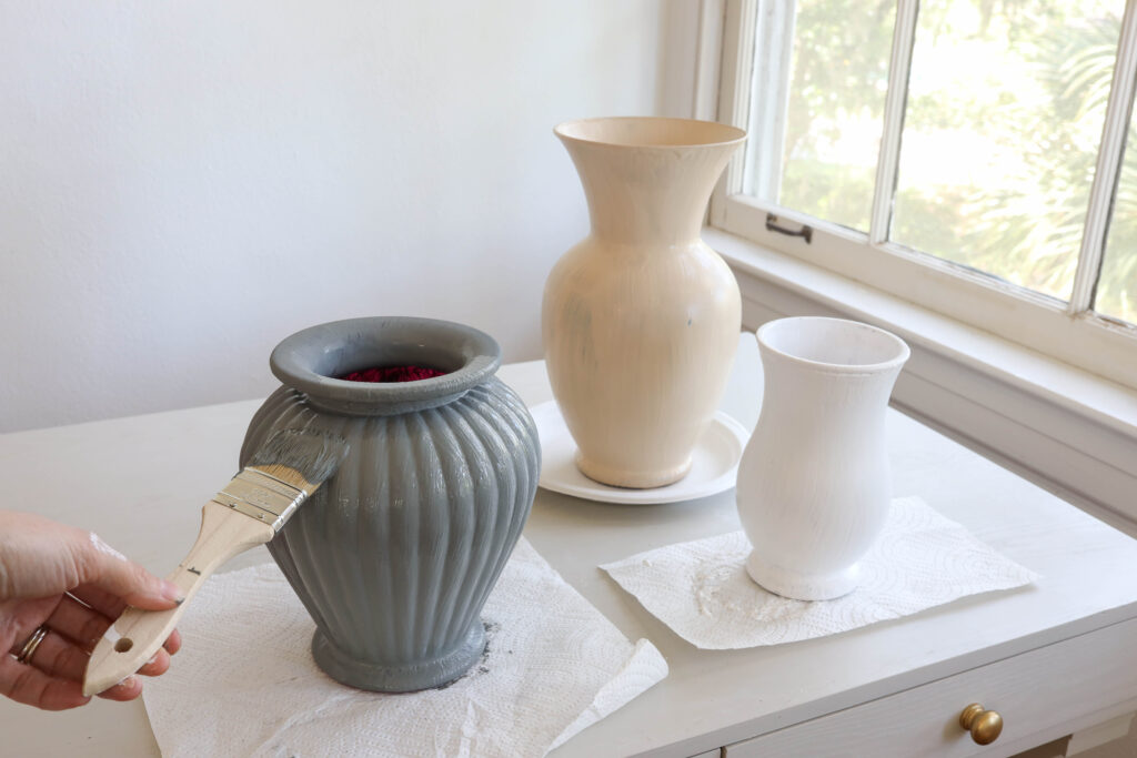 Putting the second coat of paint on a vase