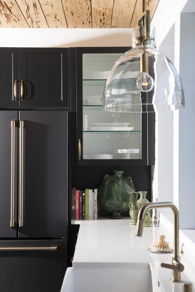 Black refrigerator and glass front cabinets