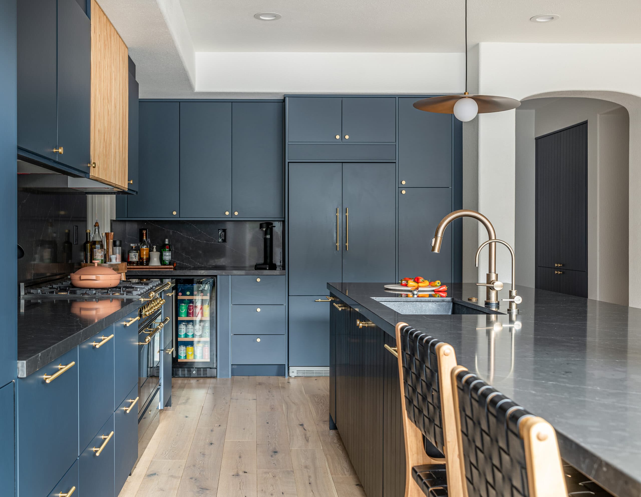 Navy blue and black kitchen with floor to ceiling cabinets