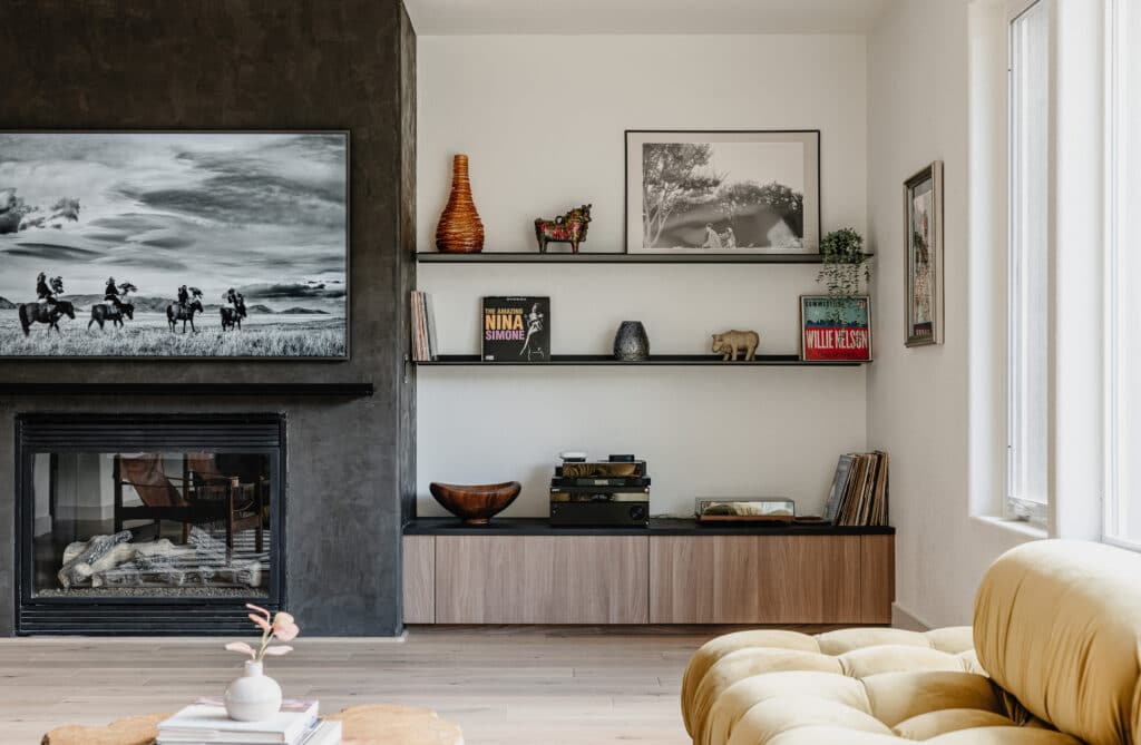 Living room with dark grey fireplace and credenza and shelves