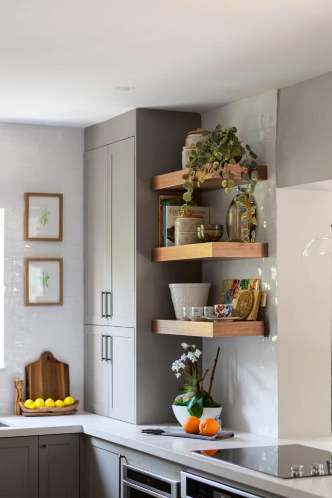 Gray kitchen with wood open shelves in the corner