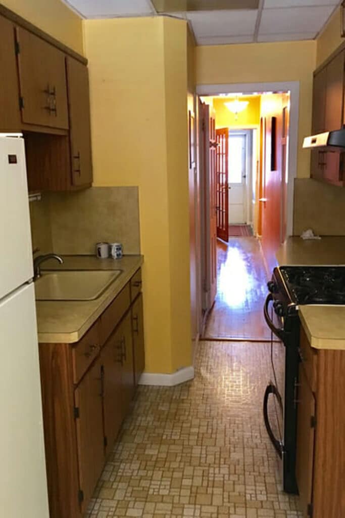 Kitchen before with yellow walls and wood cabinets