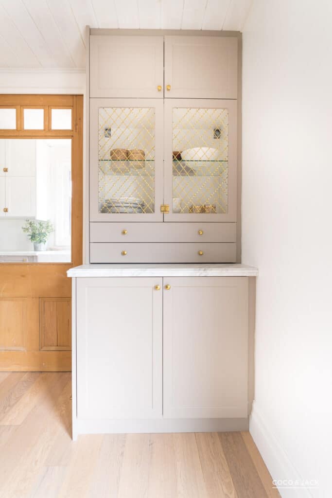 Crem colored cabinets with gold etched glass