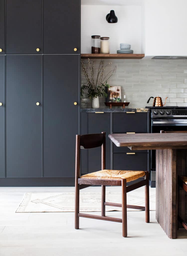 Black kitchen cabinets floor to ceiling with dining room table view