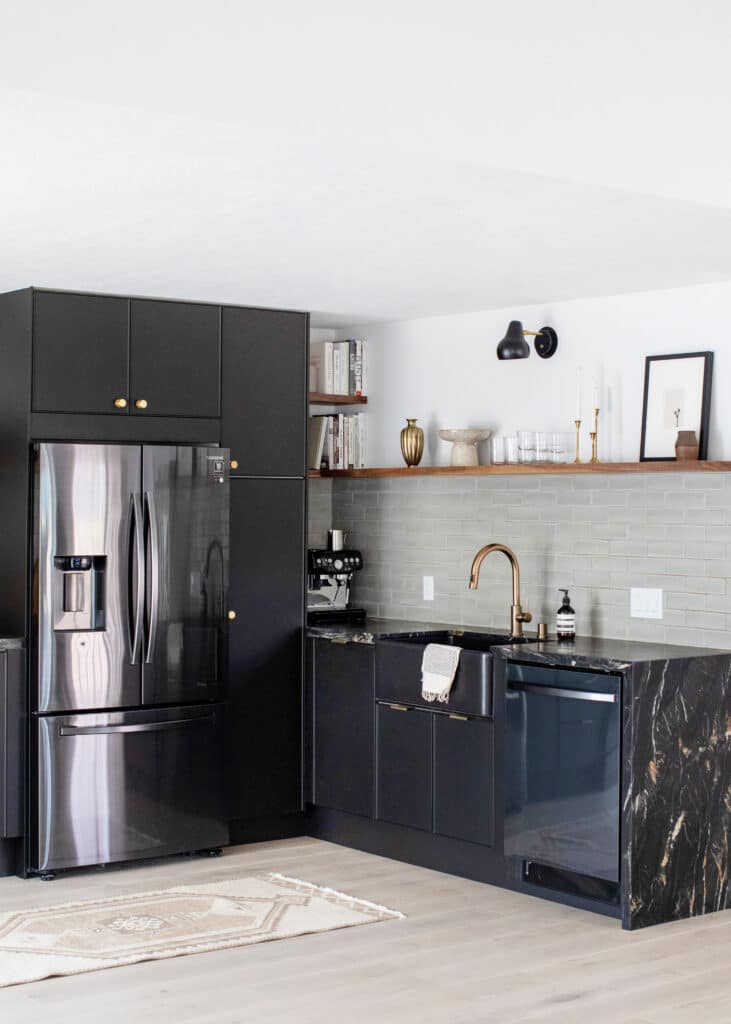 Corner view of a kitchen with black kitchen cabinets