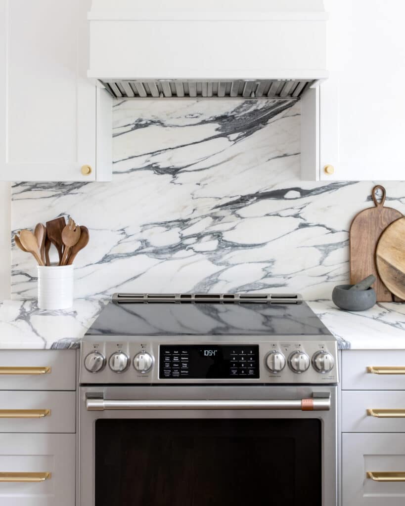 Marble backsplash between white and grey shaker cabinets