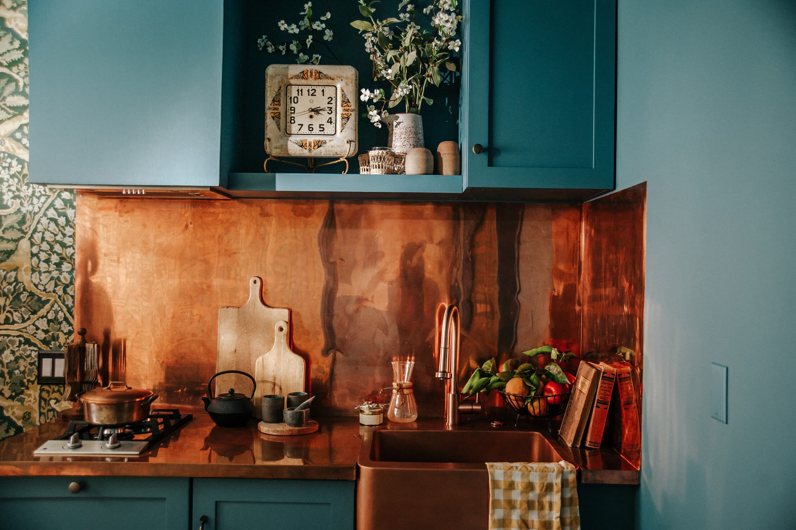 Blue kitchen cabinets and copper backsplash