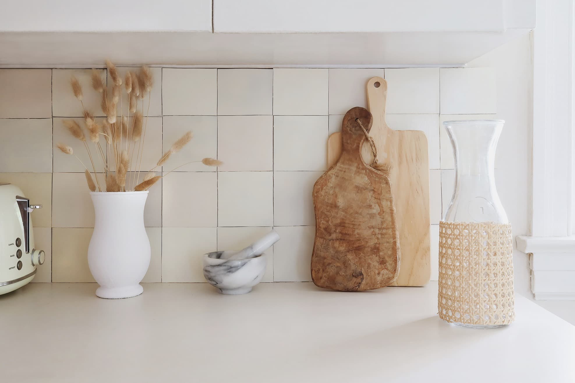 Found neutral objects in front of a creamy peel and stick kitchen backsplash