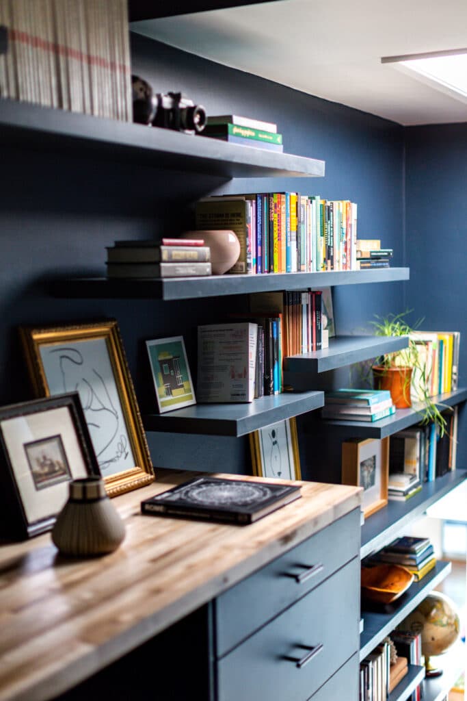 Blue painted home office with lots of built-in shelves