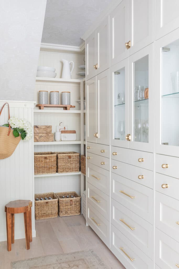 Off white pantry with glass front cabinets and open shelves