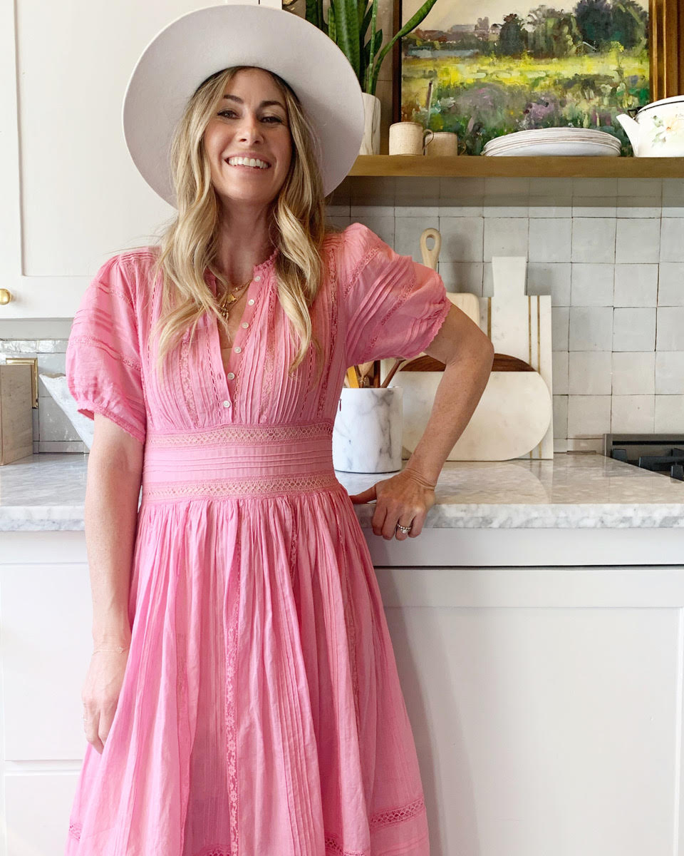 Designer Dee Murphy in a pink dress and white hat