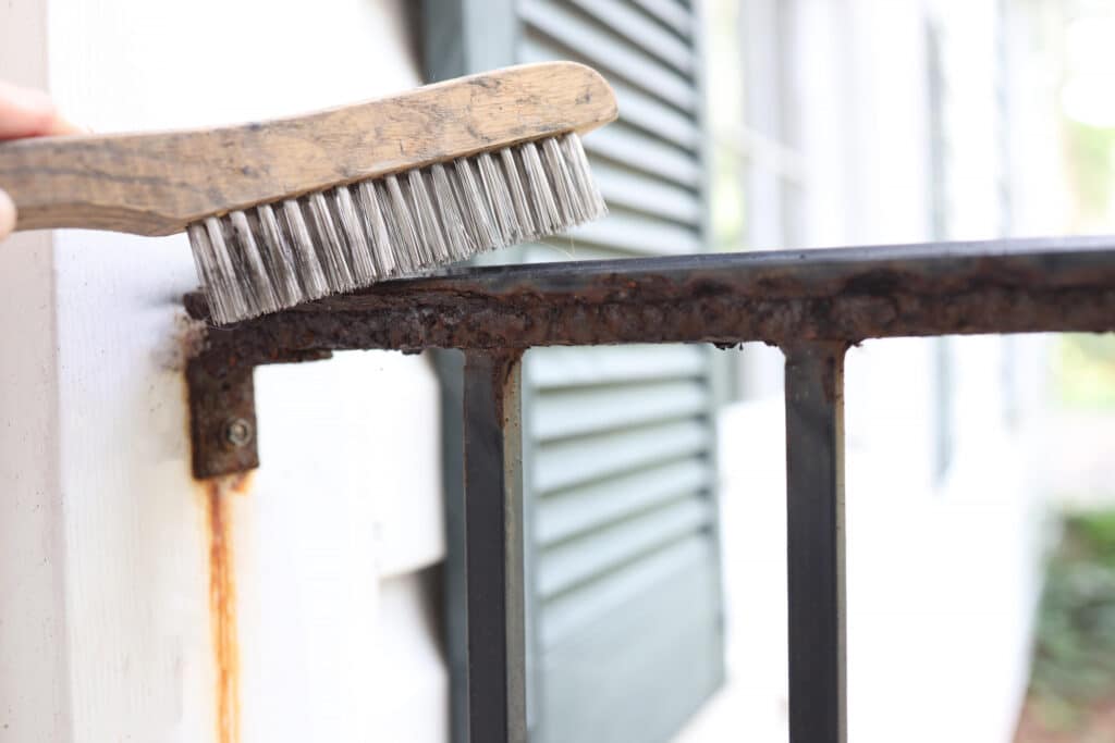 Brushing a rusted iron railing