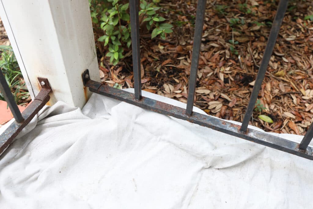 Drop cloth under a black porch railing