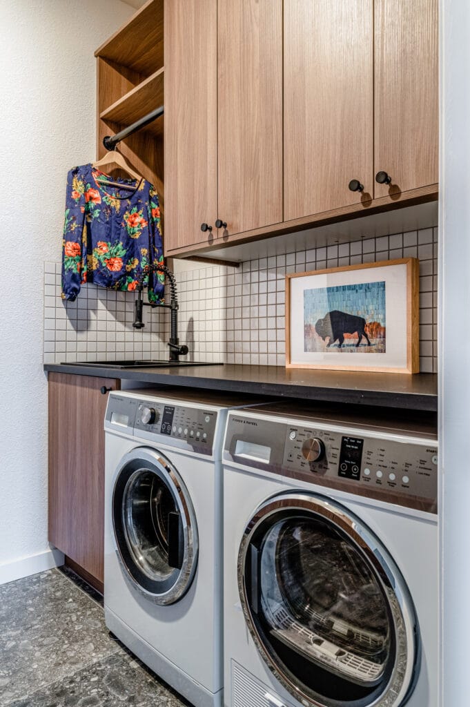 Wood cabinets with white backsplash in the laundry room