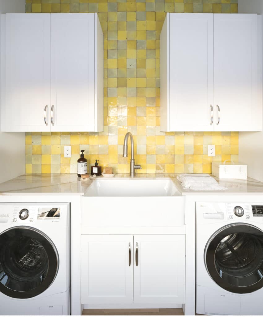 White cabinets and yellow zellige tile in the laundry room