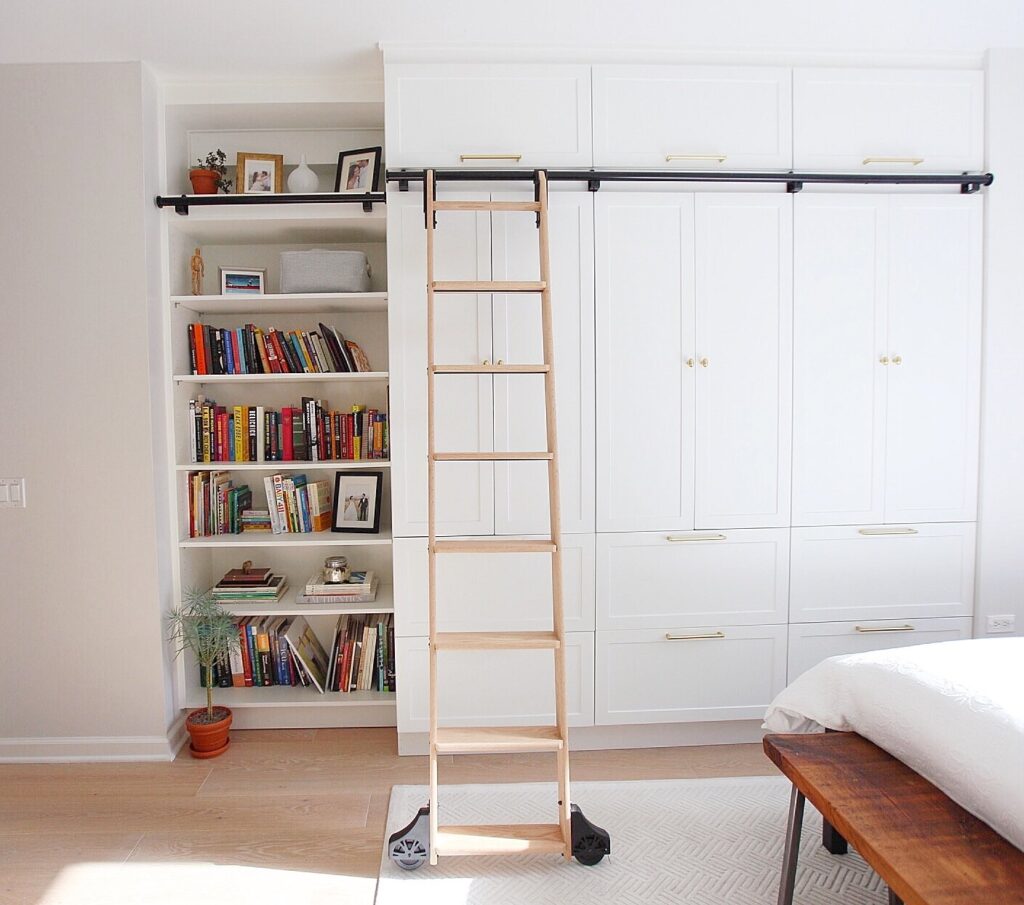 White bedroom storage with library ladder