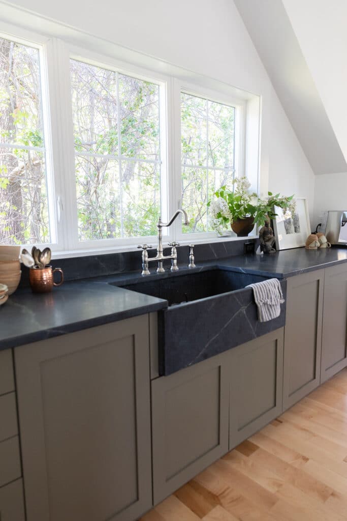 Farmhouse black sink with cabinets and windows